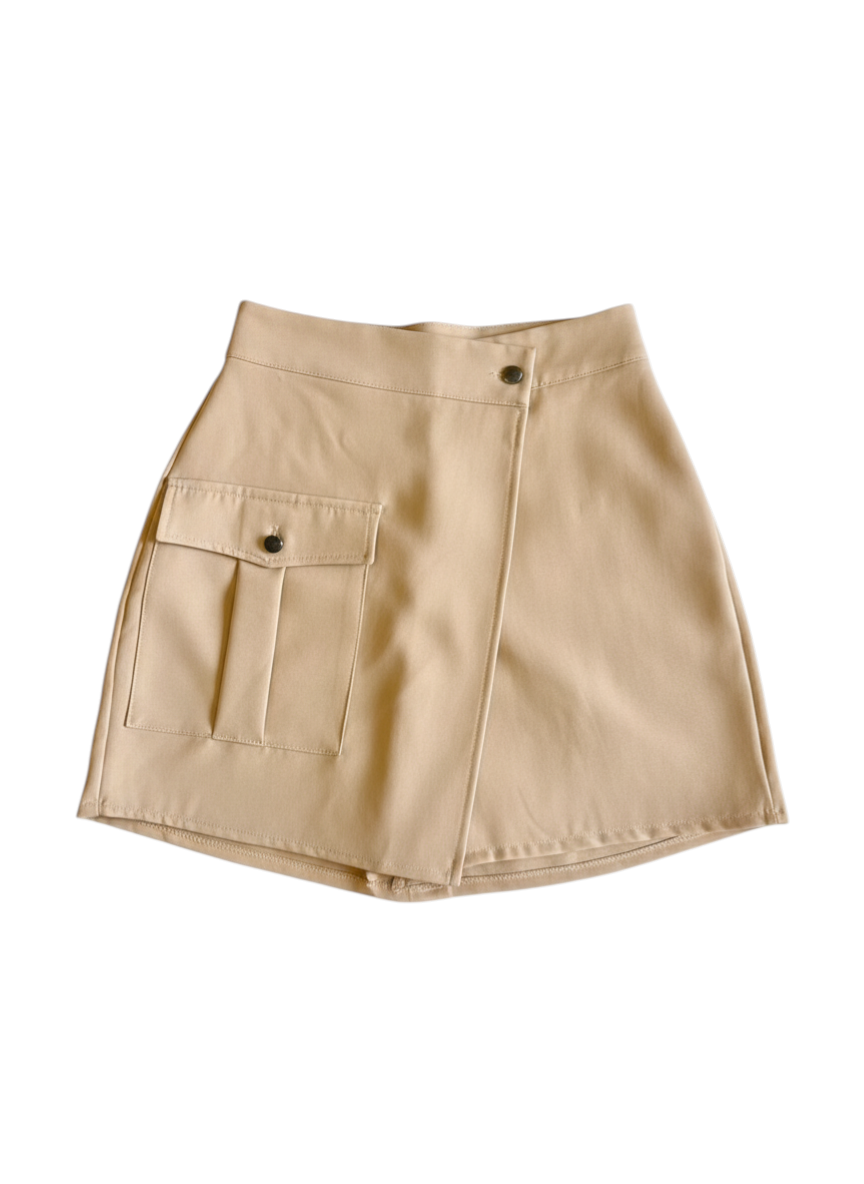 ROXANZ tan cargo skirt with button detail and flap pockets. Styled with a black crop top and sunglasses.